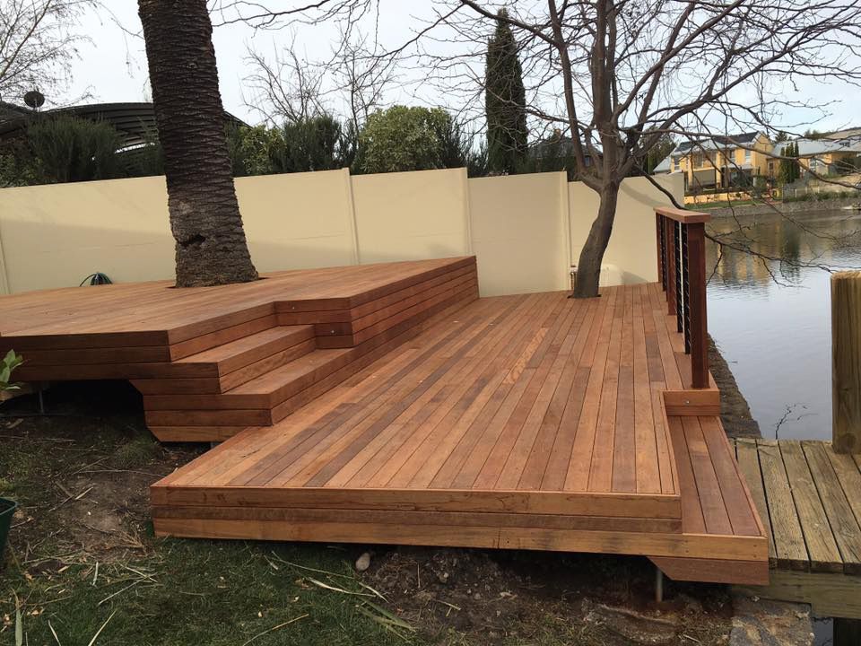 A Wooden Deck With Stairs Leading Up To It Next To A Water — P & M Maintenance Building Services in Yass River, NSW