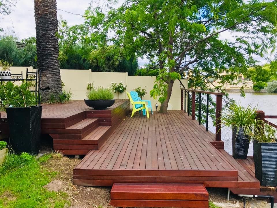 A Wooden Deck With A Blue Chair On It — P & M Maintenance Building Services in Yass River, NSW
