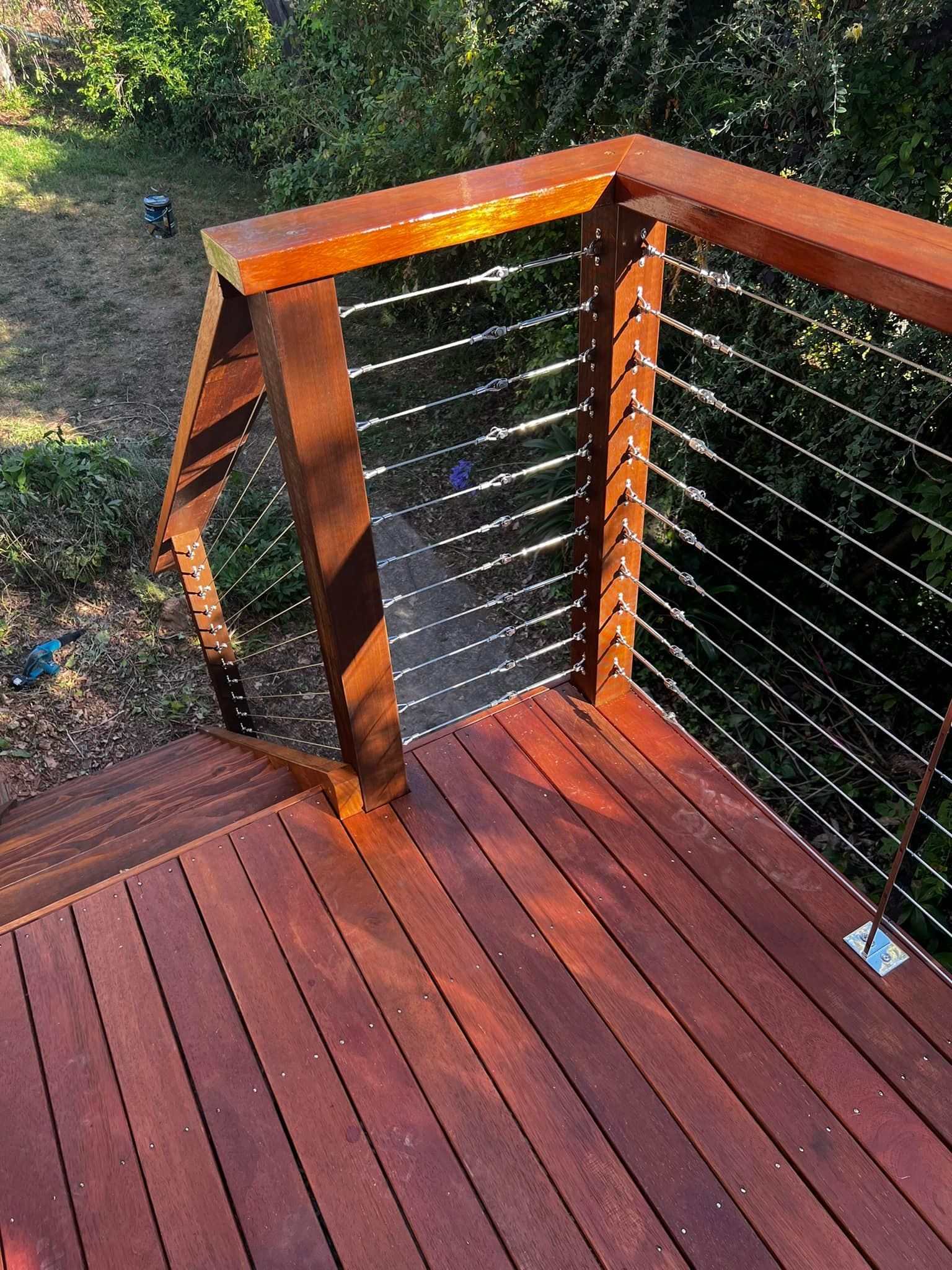 A Wooden Deck with A Metal Railing and Stairs Leading up To It — P & M Maintenance Building Services in Yass River, NSW
