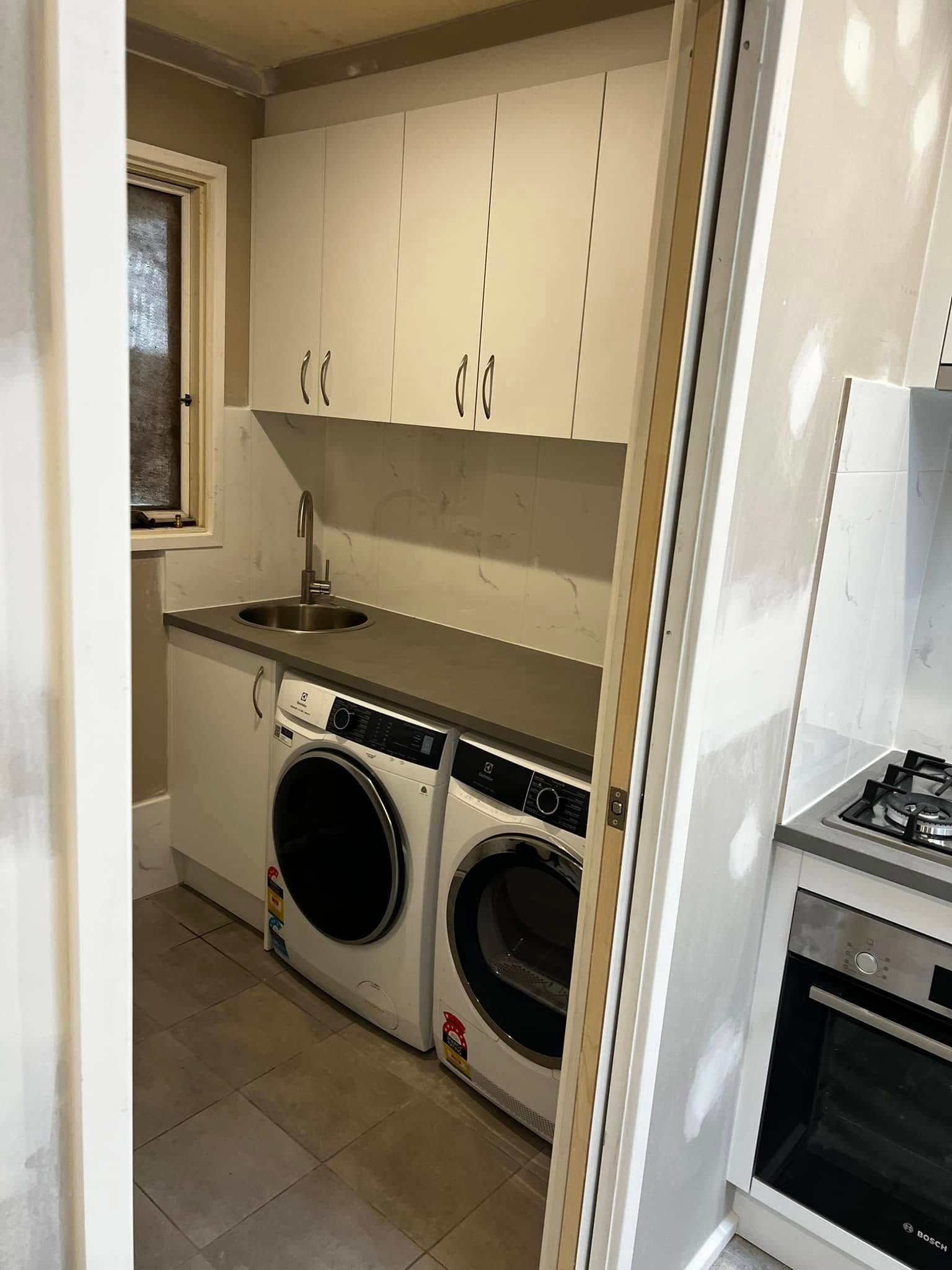 A Laundry Room with A Washer and Dryer and A Sink — P & M Maintenance Building Services in Yass River, NSW