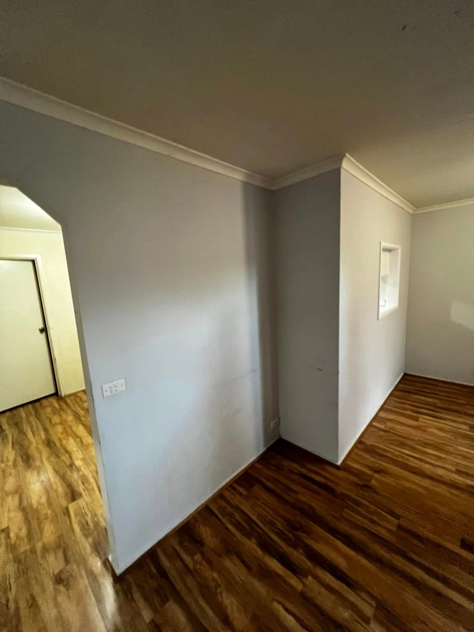 An Empty Room with Hardwood Floors and White Walls — P & M Maintenance Building Services in Yass River, NSW