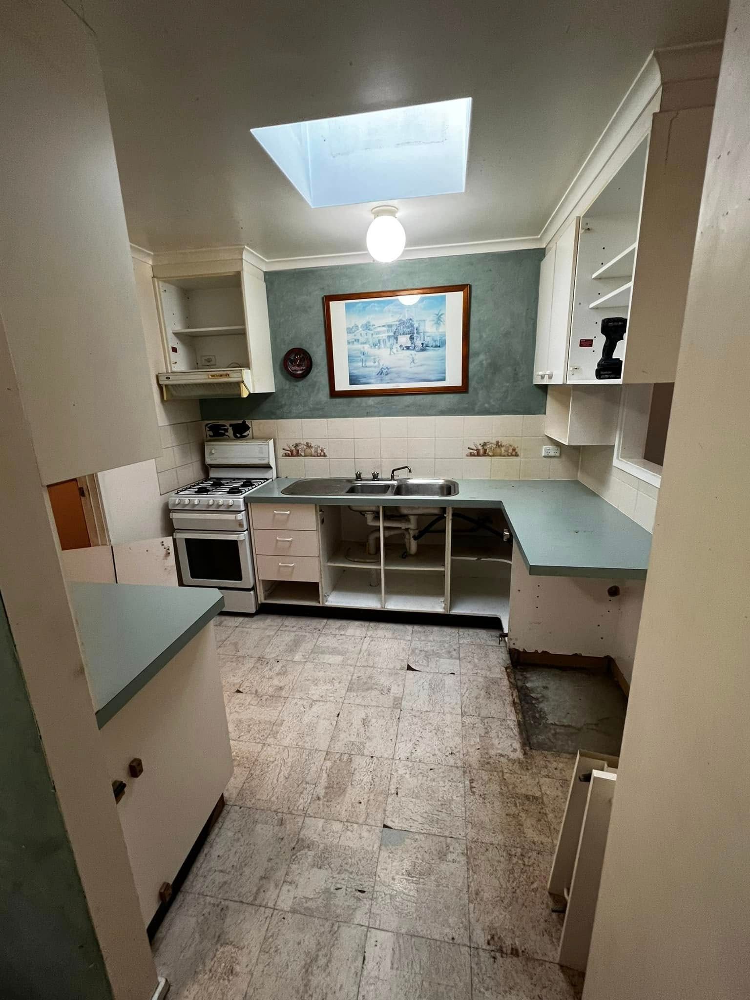A Kitchen with A Stove, Cabinets and A Picture on The Wall — P & M Maintenance Building Services in Yass River, NSW