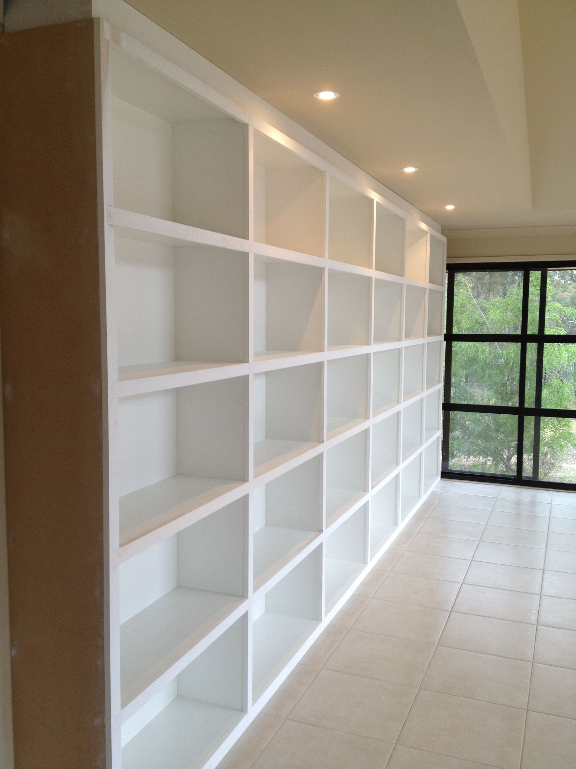 A Long Row of White Shelves in A Room with A Window — P & M Maintenance Building Services in Belconnen, ACT