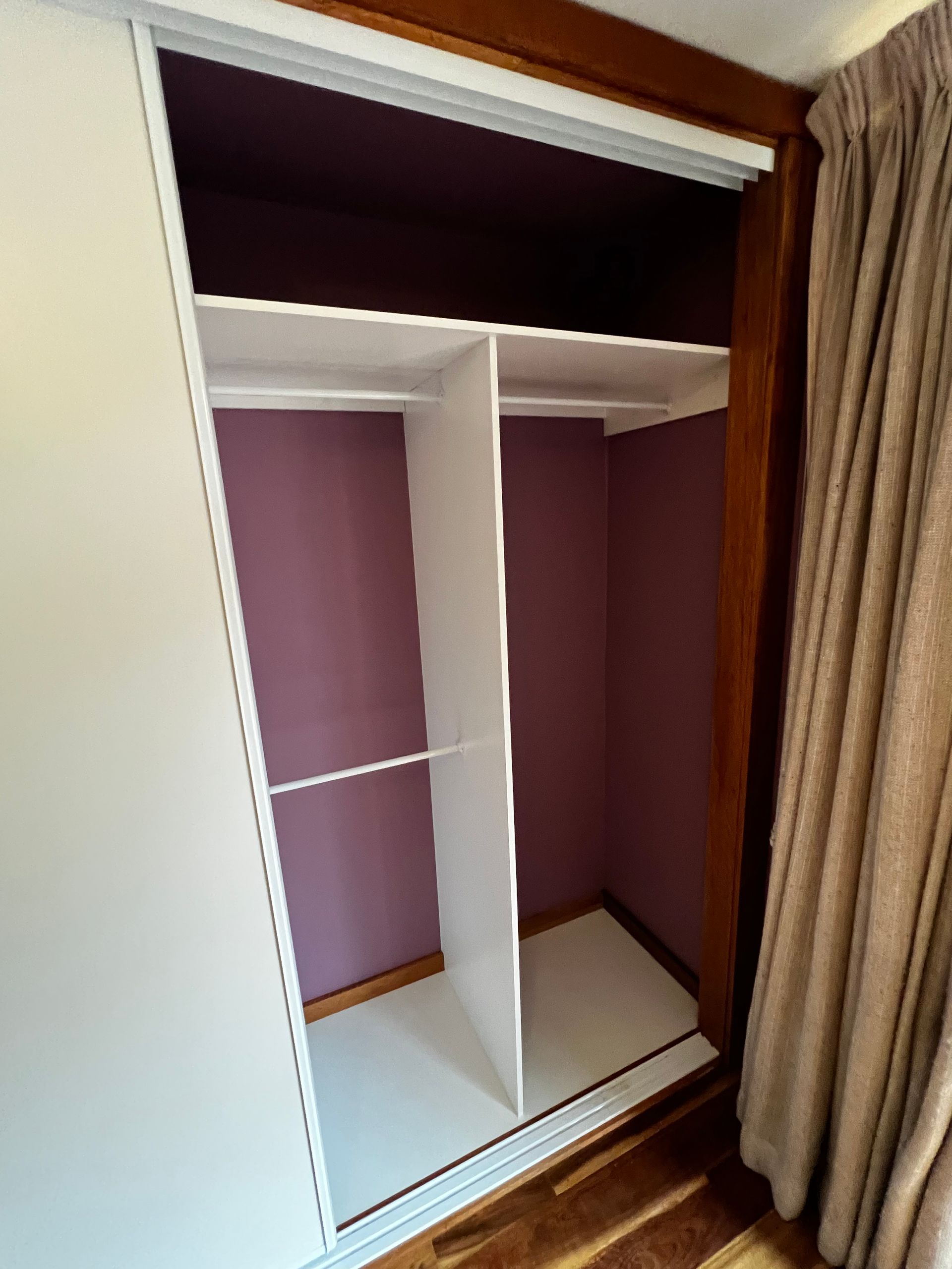 An Empty Closet with Purple Walls and White Shelves — P & M Maintenance Building Services in Murrumbateman, NSW