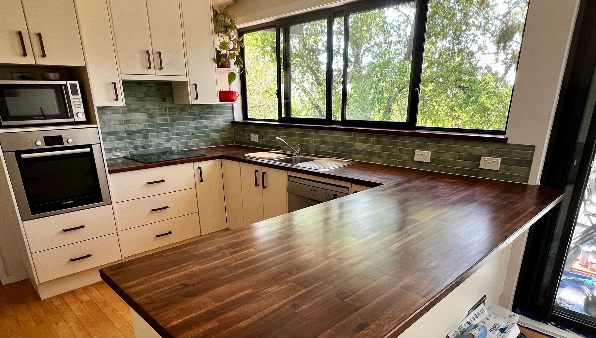 A Kitchen with White Cabinets and A Wooden Counter Top — P & M Maintenance Building Services in Gungahlin, ACT