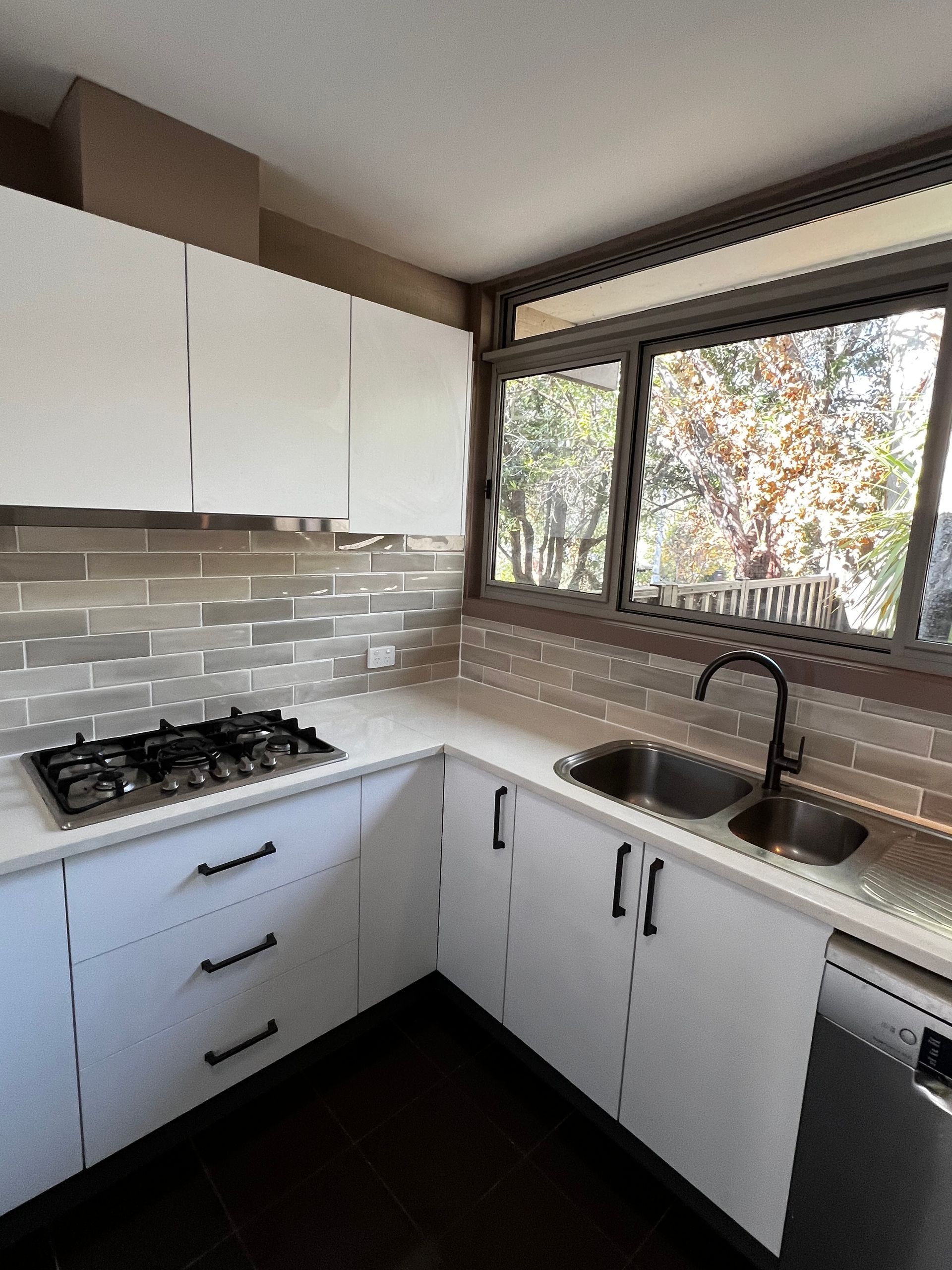 A Kitchen with White Cabinets and Stainless Steel Appliances — P & M Maintenance Building Services in Yass River, NSW