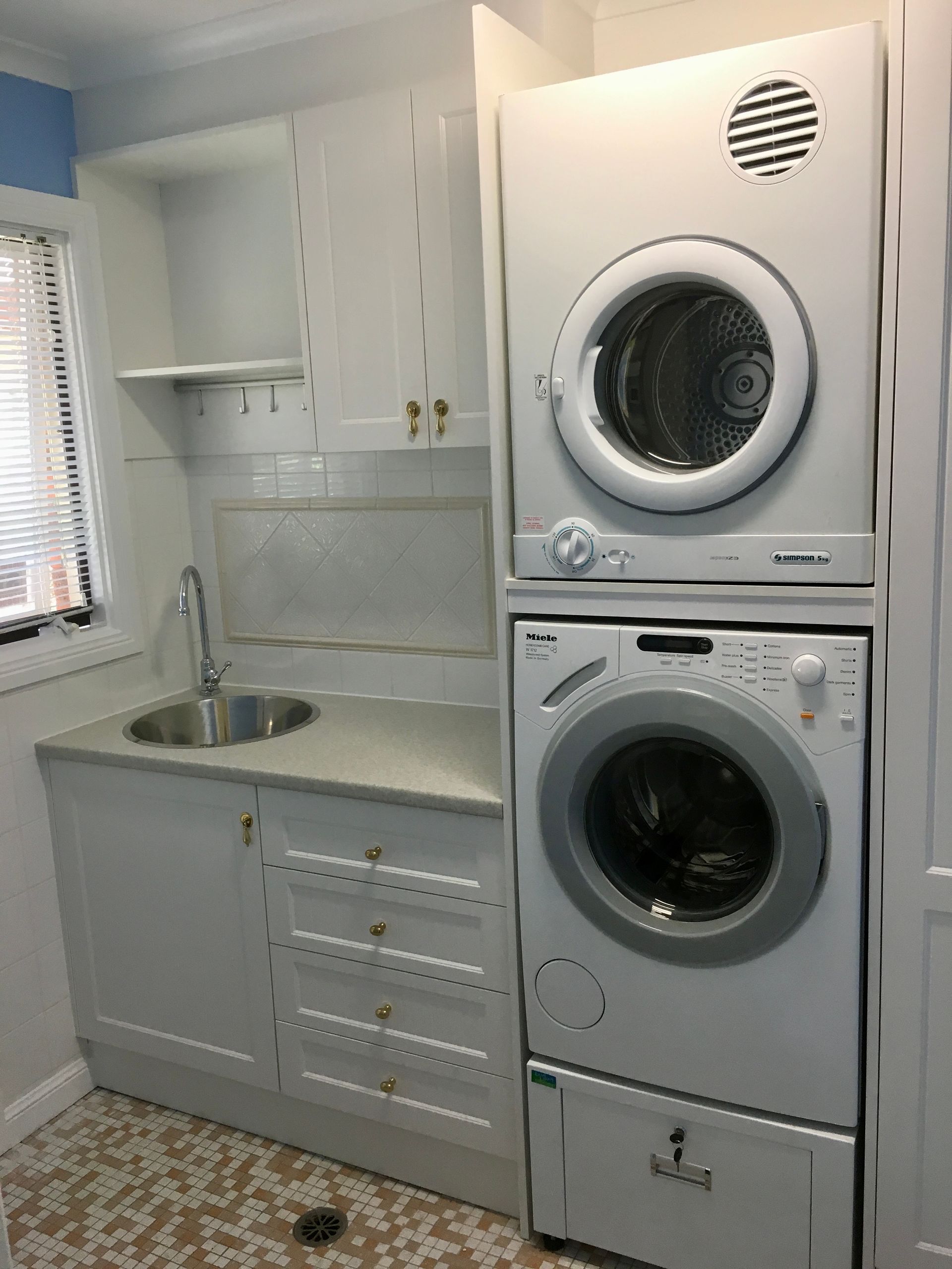 A Laundry Room with Wooden Cabinets, a Washer and a Window — P & M Maintenance Building Services in Yass River, NSW