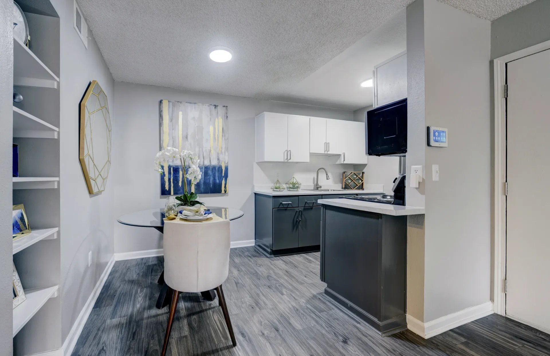 Kitchen and dining area with modern gray cabinets, white countertops, and a small dining table.