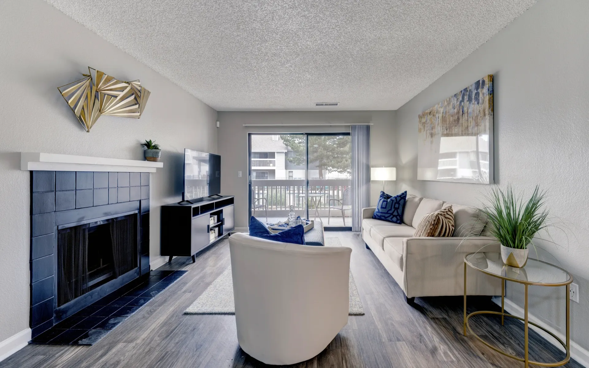Living room with fireplace, TV, sofa, and balcony access.