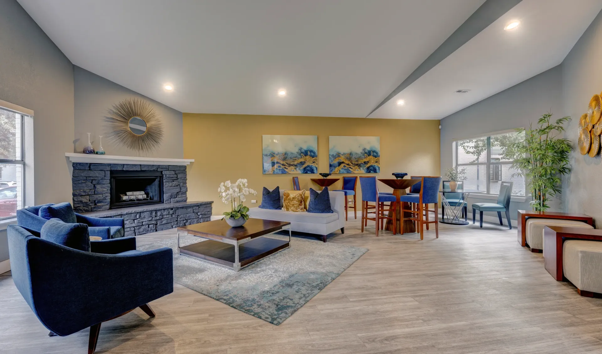 A communal living room with a stone fireplace, comfortable seating, and a bar area.