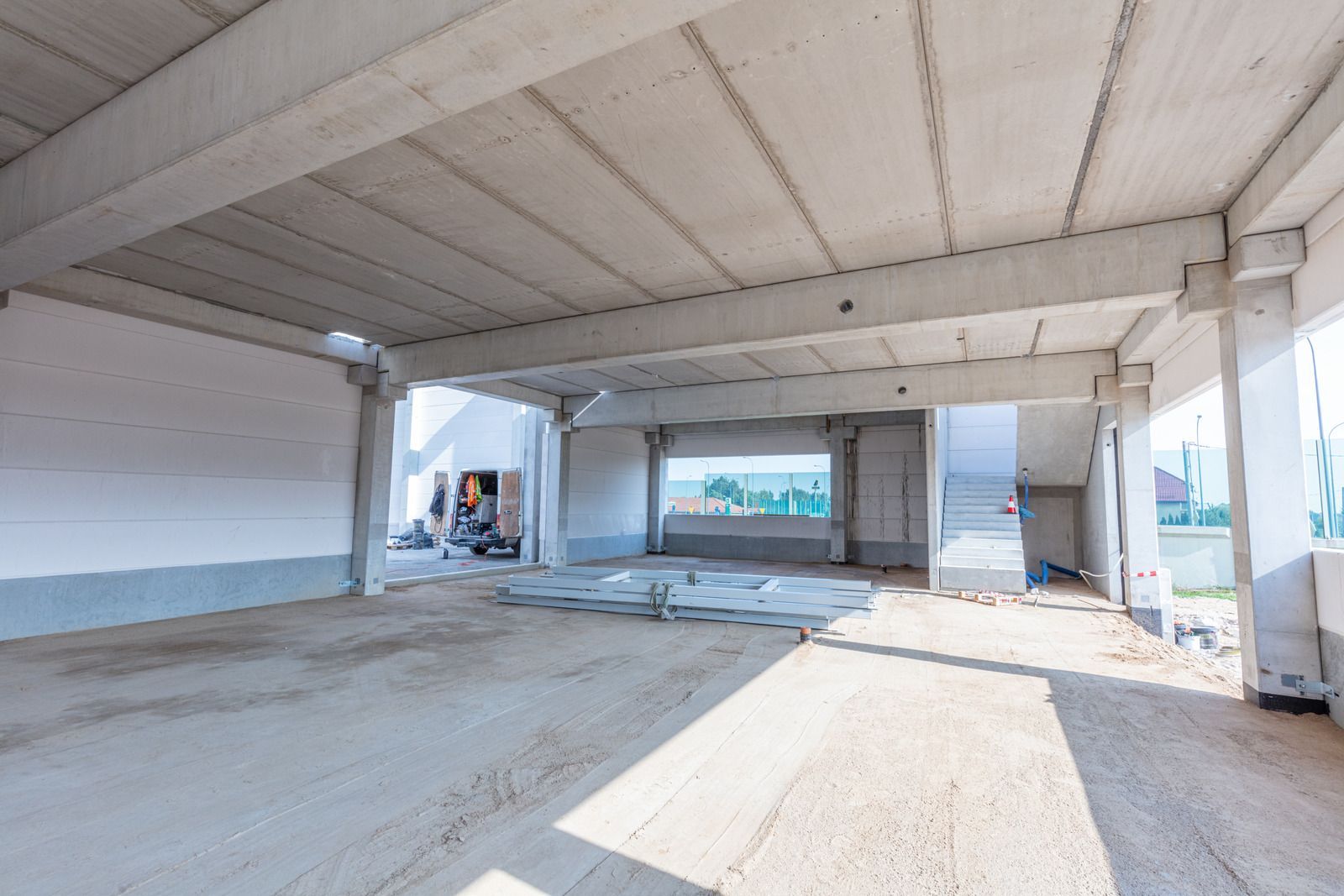 Interior of a concrete building under construction; walls, floors, and ceiling are bare.