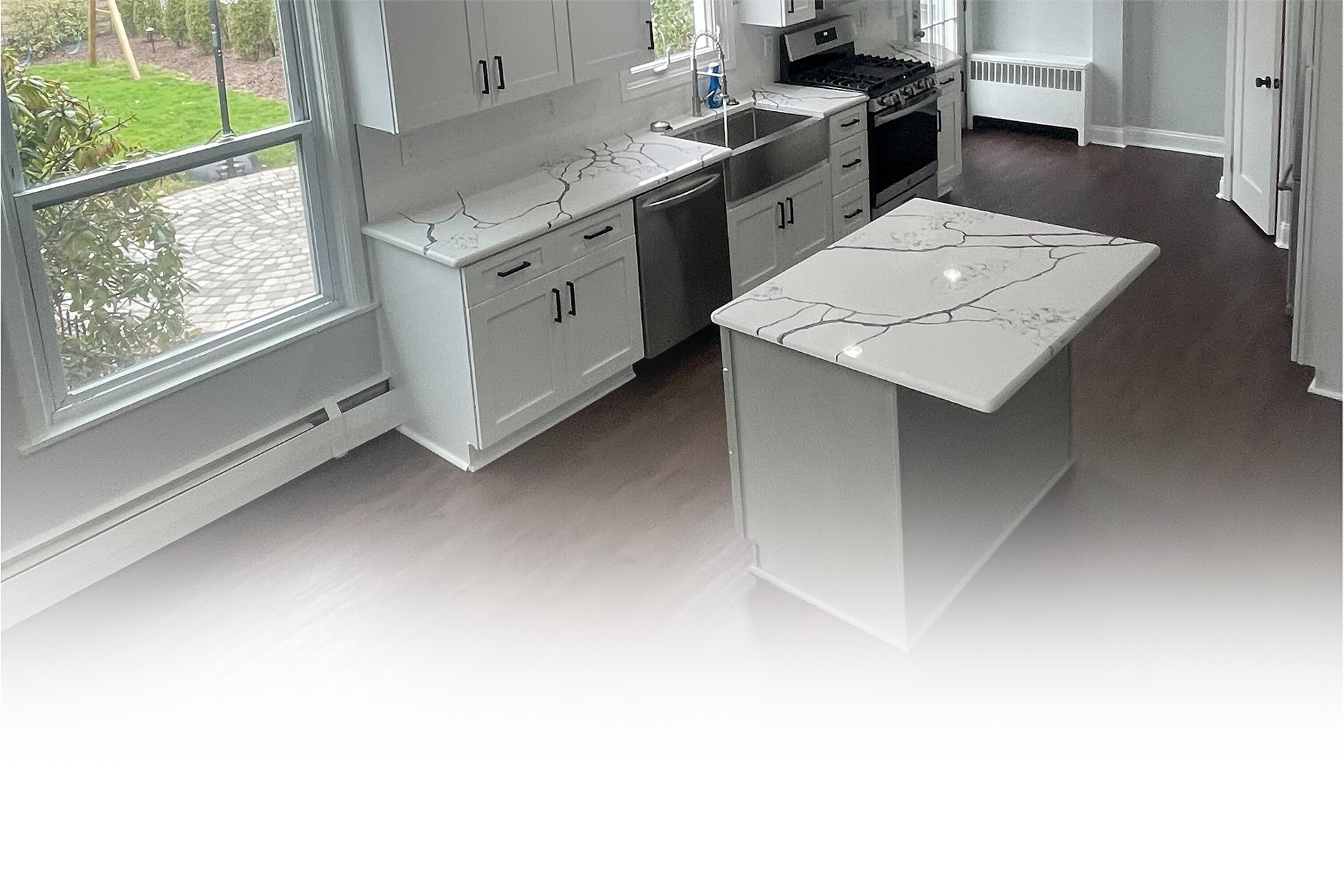 A kitchen with white cabinets and a large island in the middle.