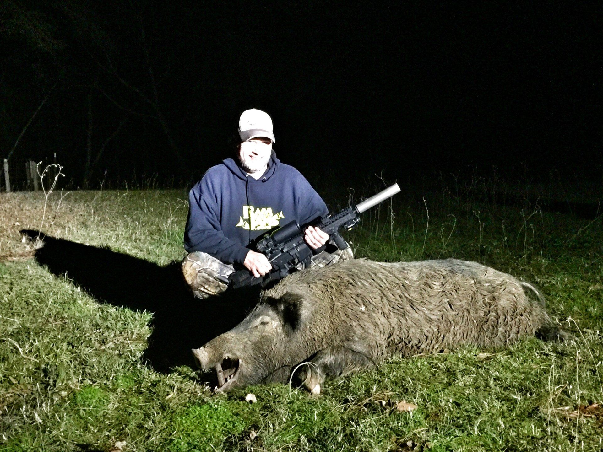 Guided night hog hunt in East Texas, hunter kneeling with harvested boar
