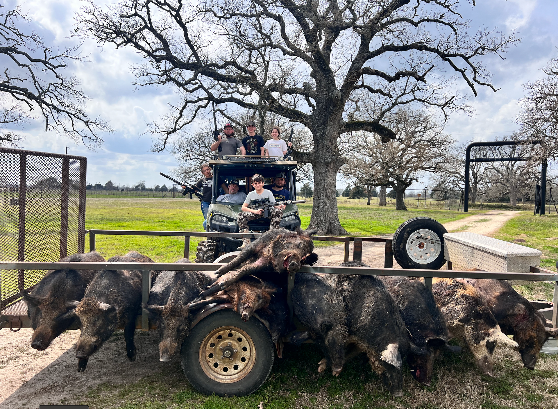 Hunting party on a vehicle with harvested wild hogs after a guided thermal hunt in East Texas