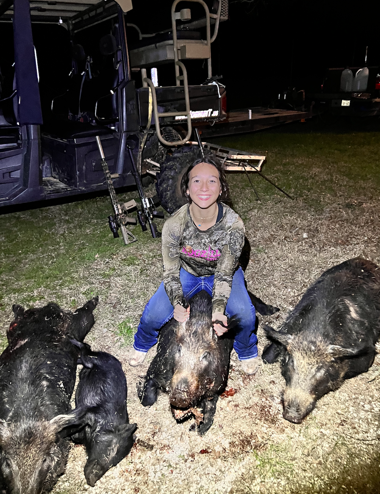 Young hunter with three feral hogs taken on a guided night hunt in Texas