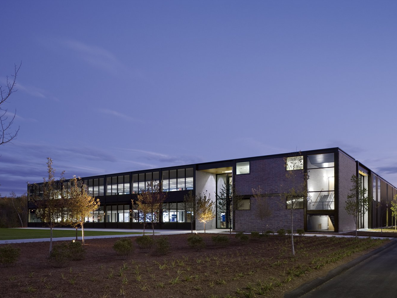 A large building with a lot of windows is lit up at night