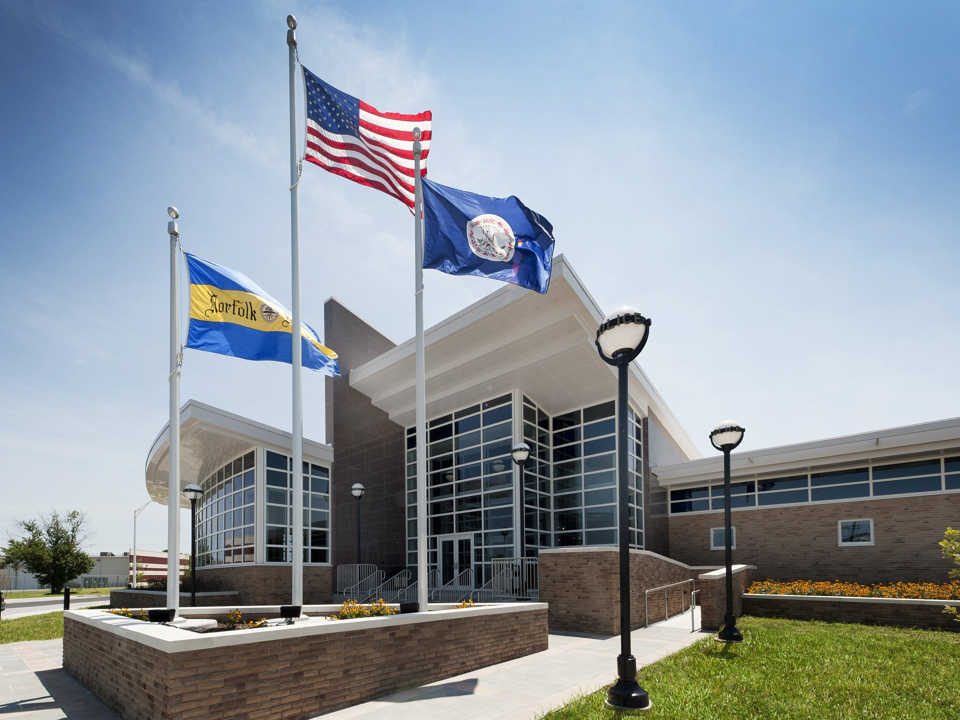 Three flags are flying in front of a building