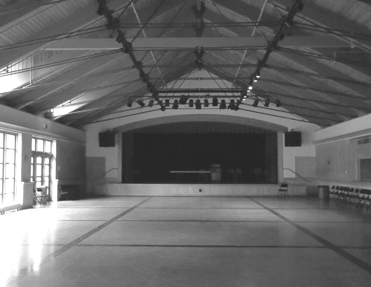 A black and white photo of an empty auditorium with a stage