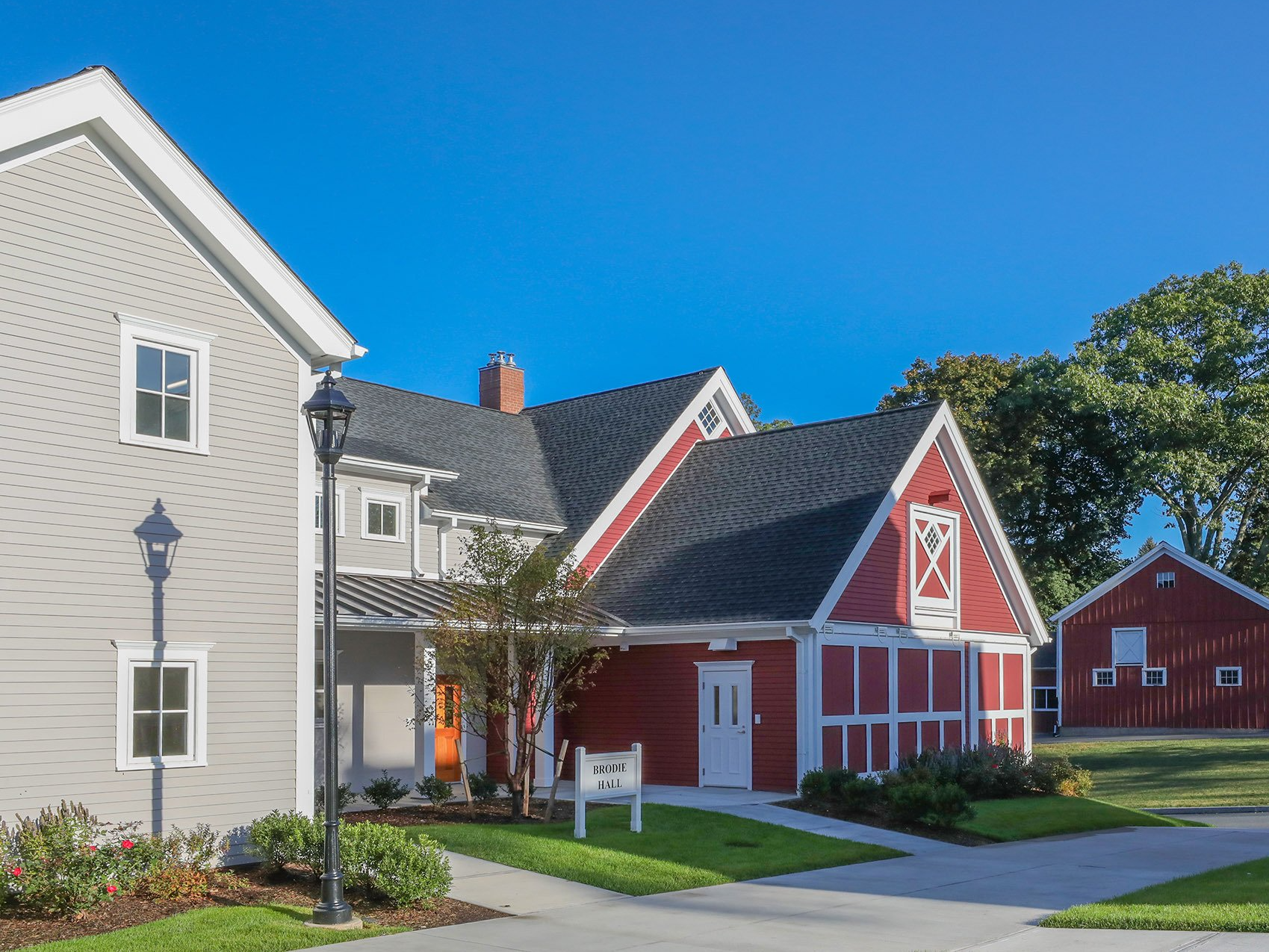 A row of houses with a red barn in the middle