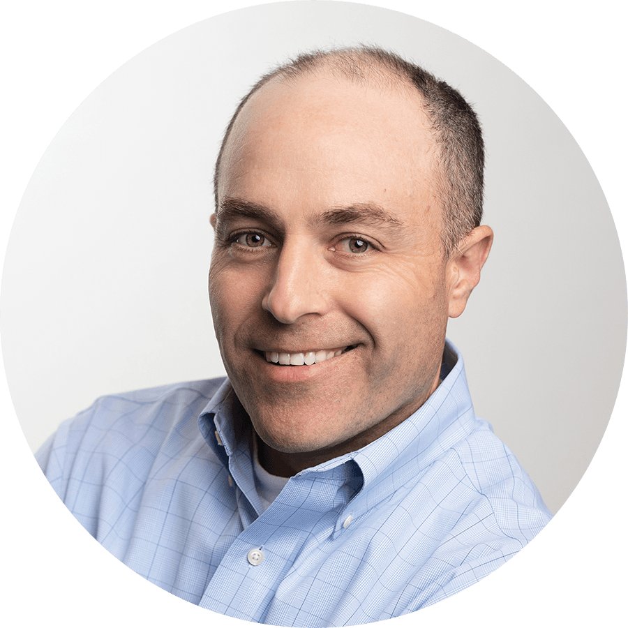 A man in a blue shirt is smiling in a circle.