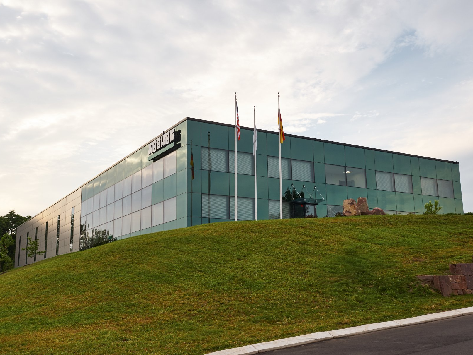 A large green building with flags in front of it