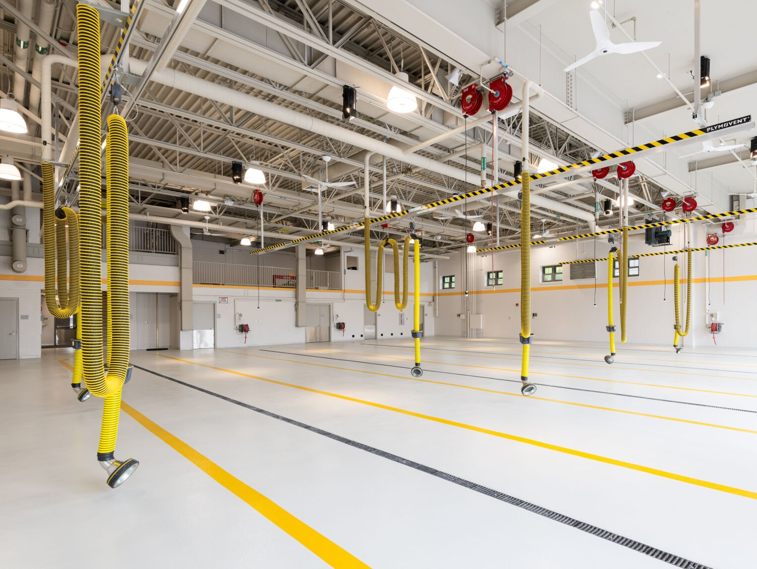 A large empty warehouse with yellow lines on the floor.