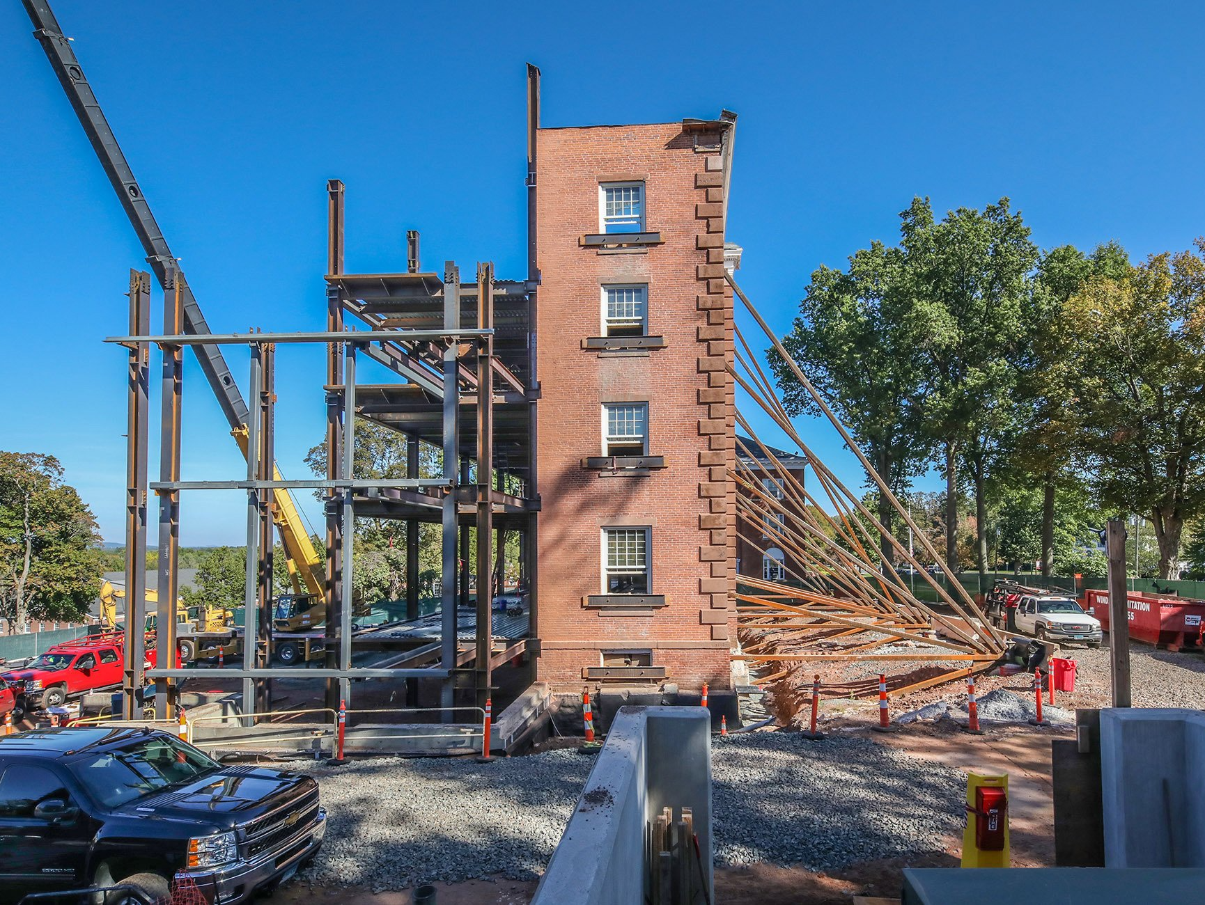 A brick building under construction with a crane in the background