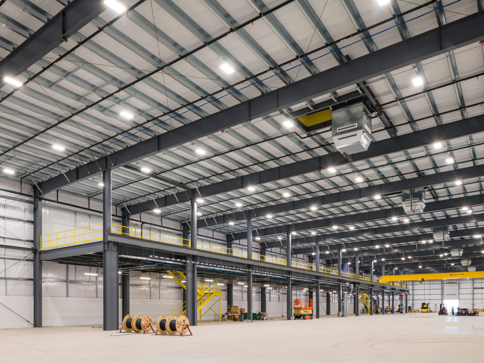 The inside of a large warehouse with a lot of lights on the ceiling.