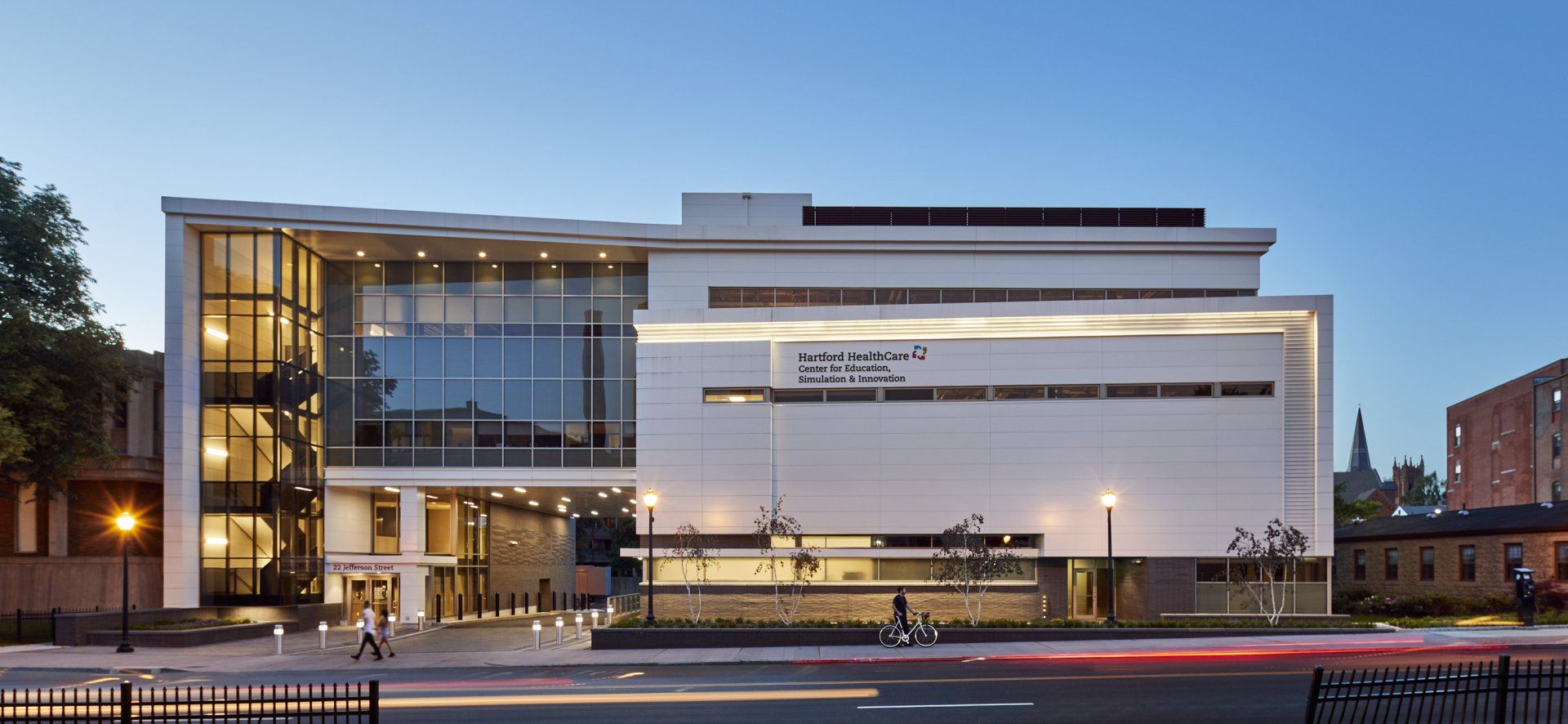 A large white building with a lot of windows is lit up at night.