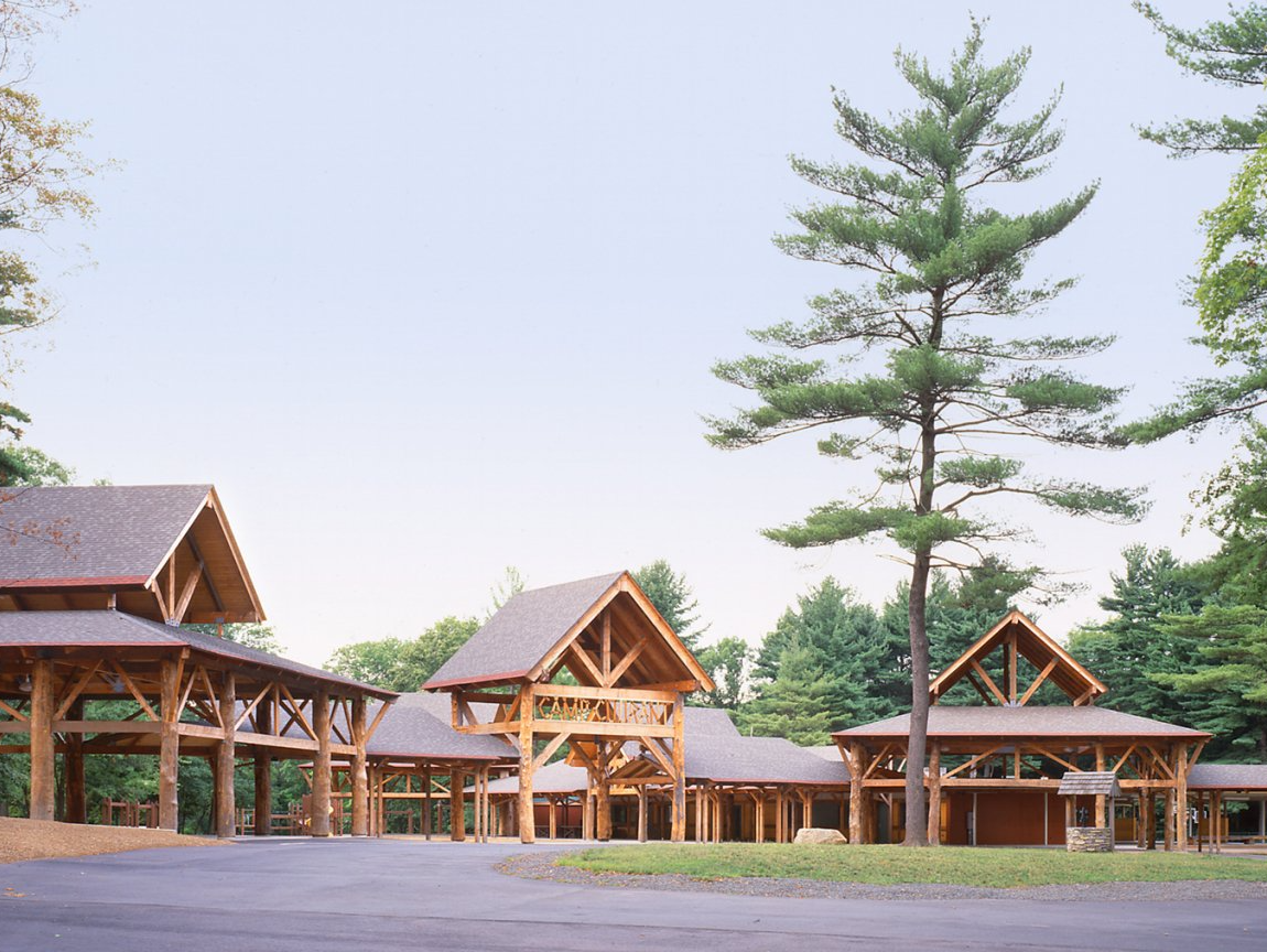 A row of wooden buildings with trees in the background