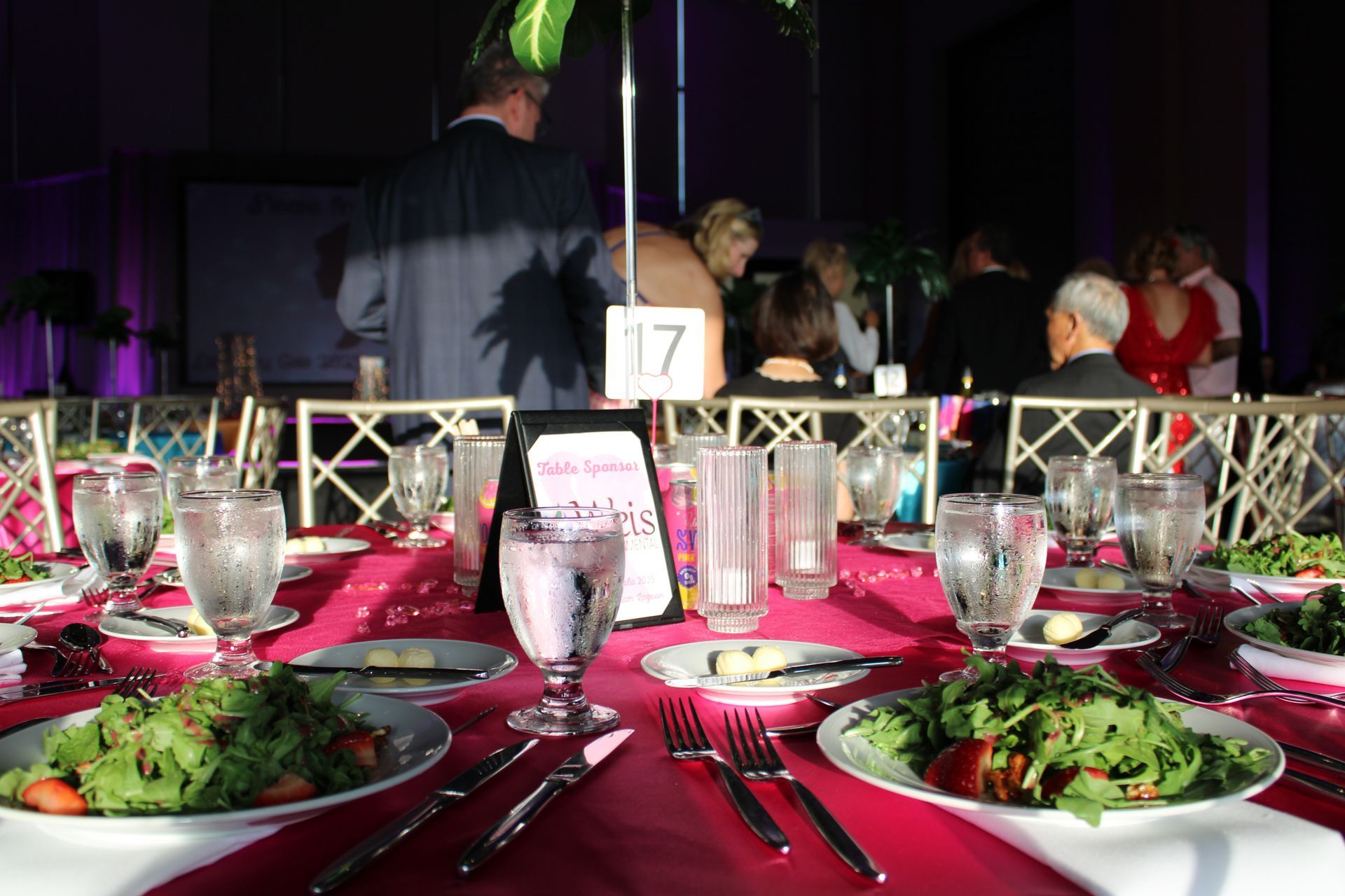 Elegant banquet table set with salads, wine glasses, and table number 17 at a formal event
