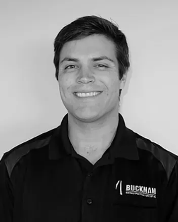 Man in black polo shirt smiles at camera. Bucknam logo on shirt.