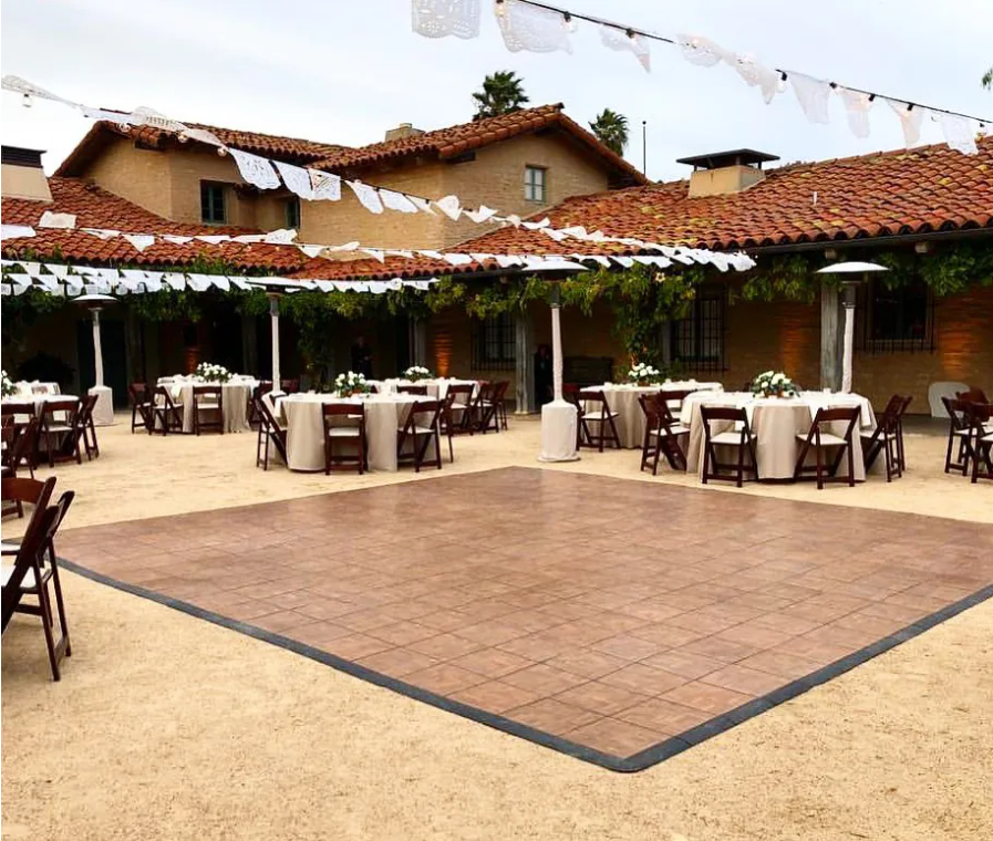 A dance floor with tables and chairs in front of a house