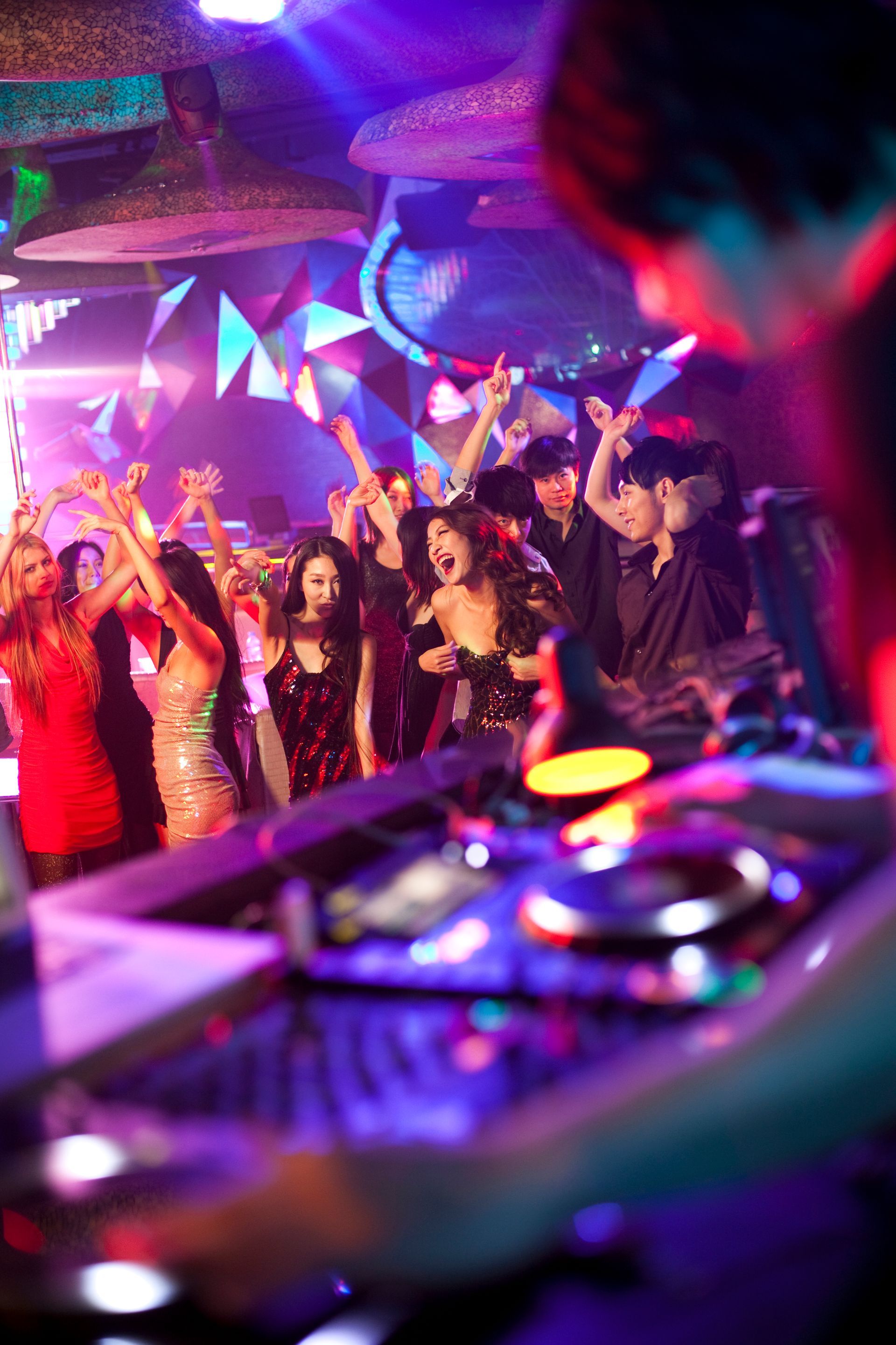 A dj is playing music to a crowd of people at a party.