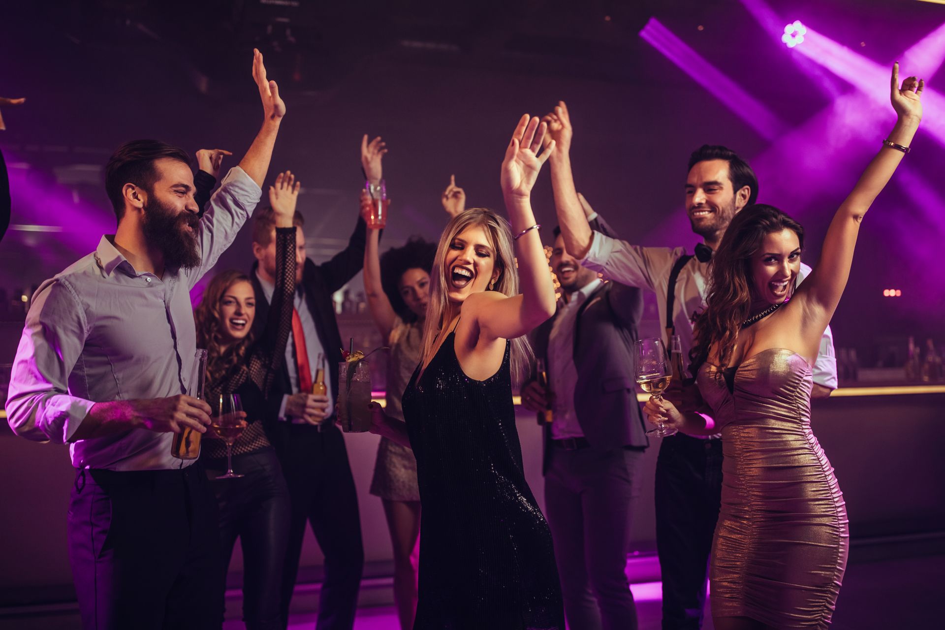 A group of people are dancing at a party in a club.