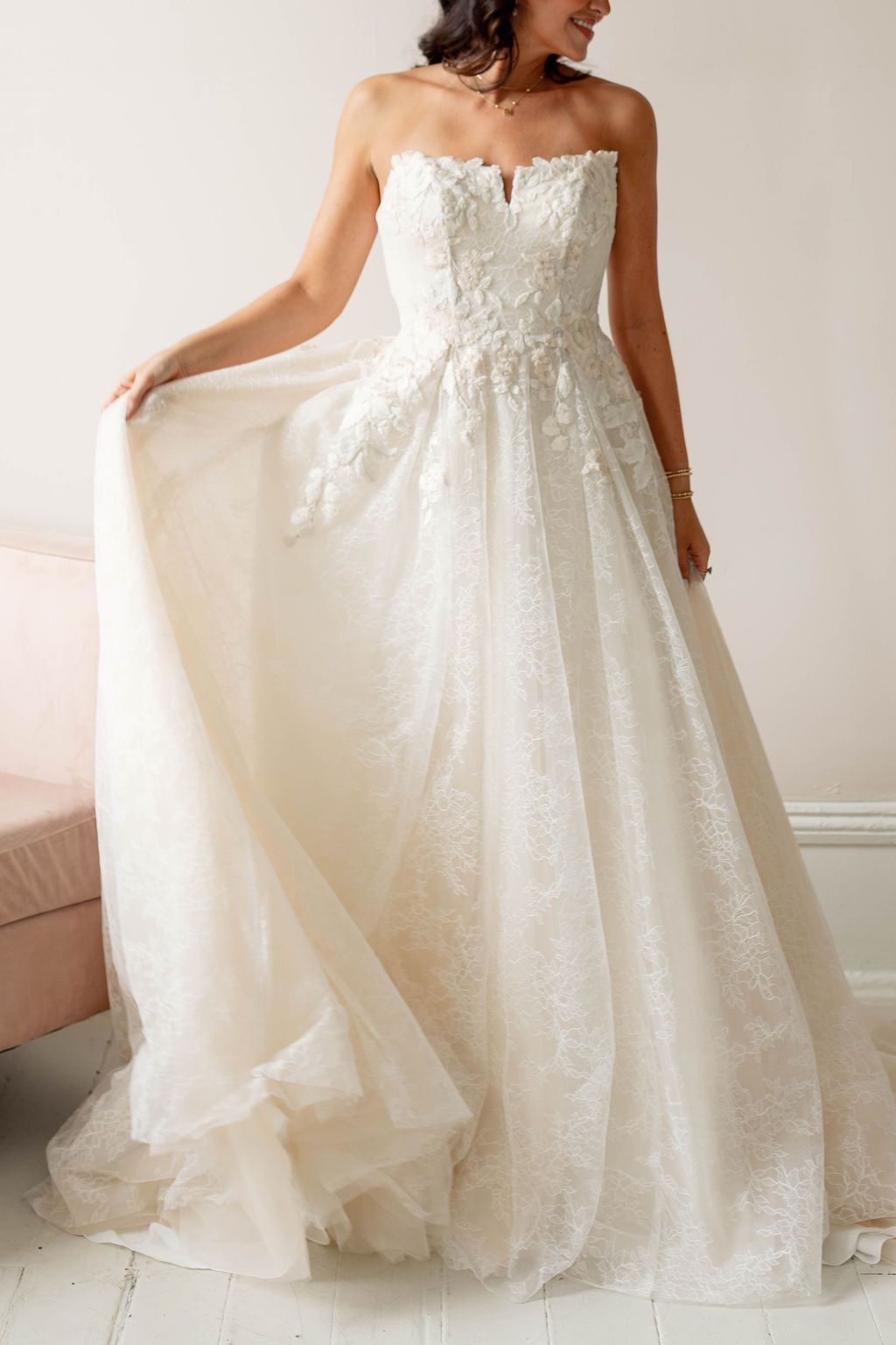 Ivory strapless wedding dress with lace bodice and flowing tulle skirt, shown on a model