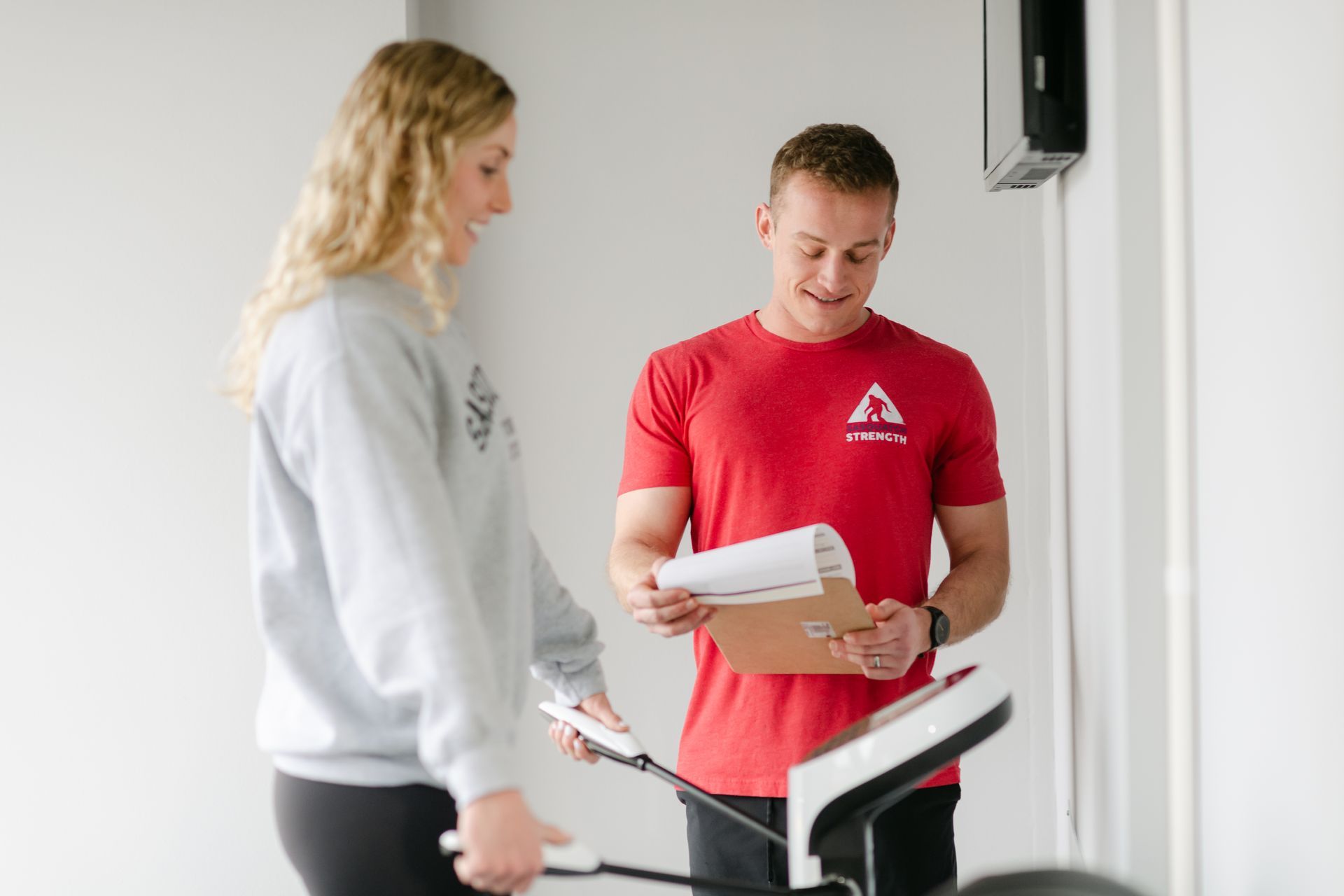 A man and a woman are standing next to each other in a gym.
