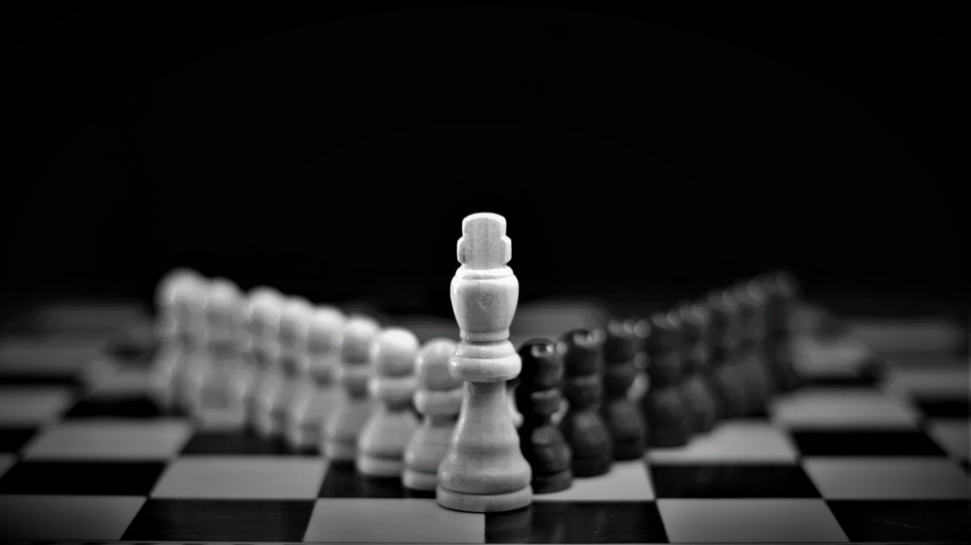 Black and white chess pieces arranged across a board