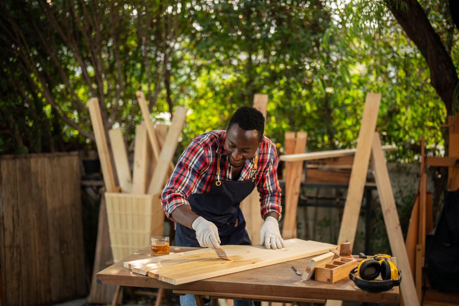 A man is cutting a piece of wood on a table.