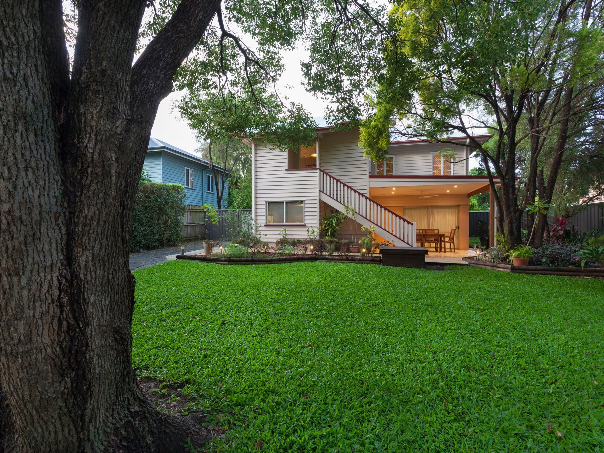A stylish Australian home at dusk with a cut lawn.