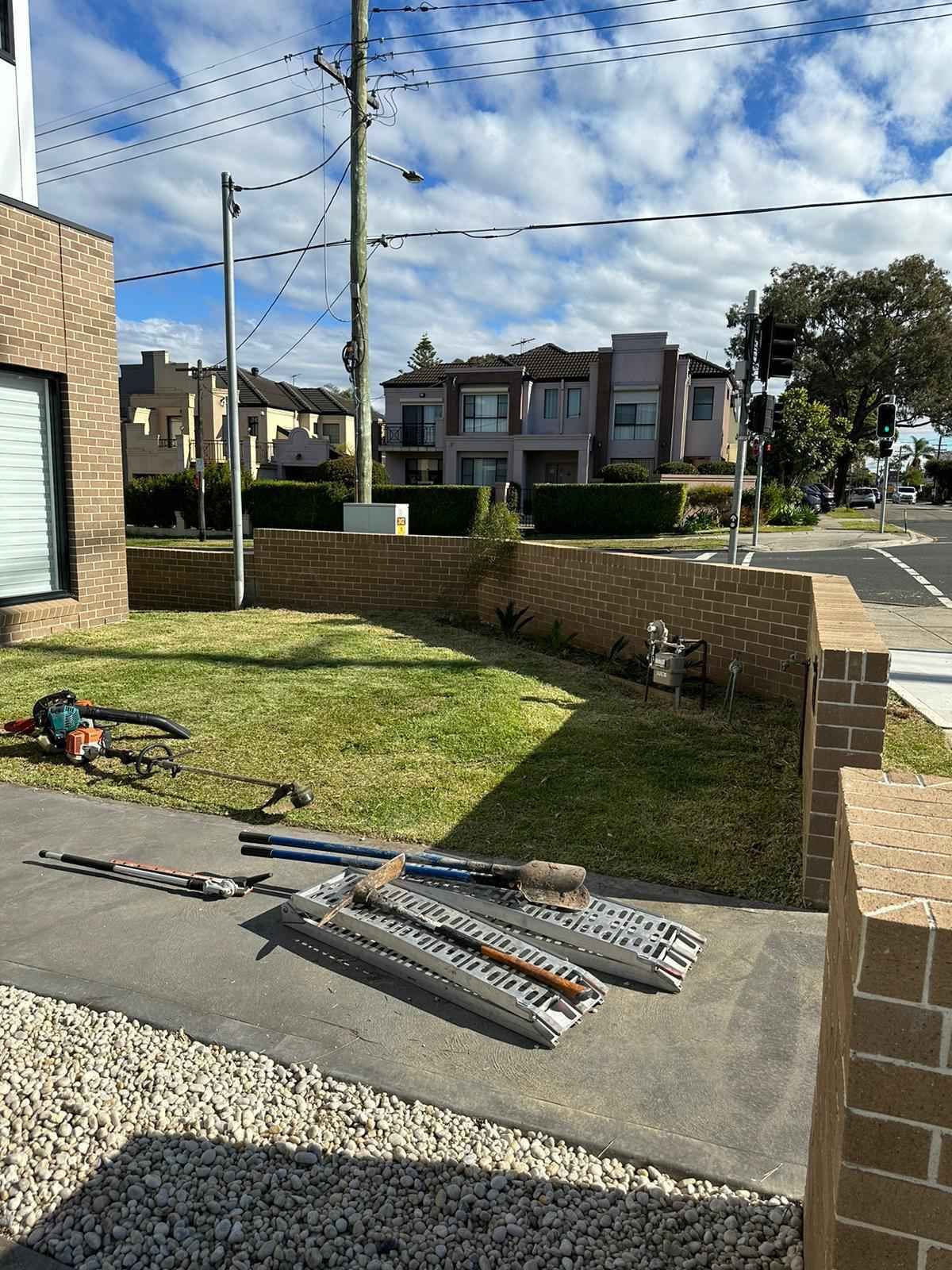 A bunch of tools are laying on the ground in front of a house.