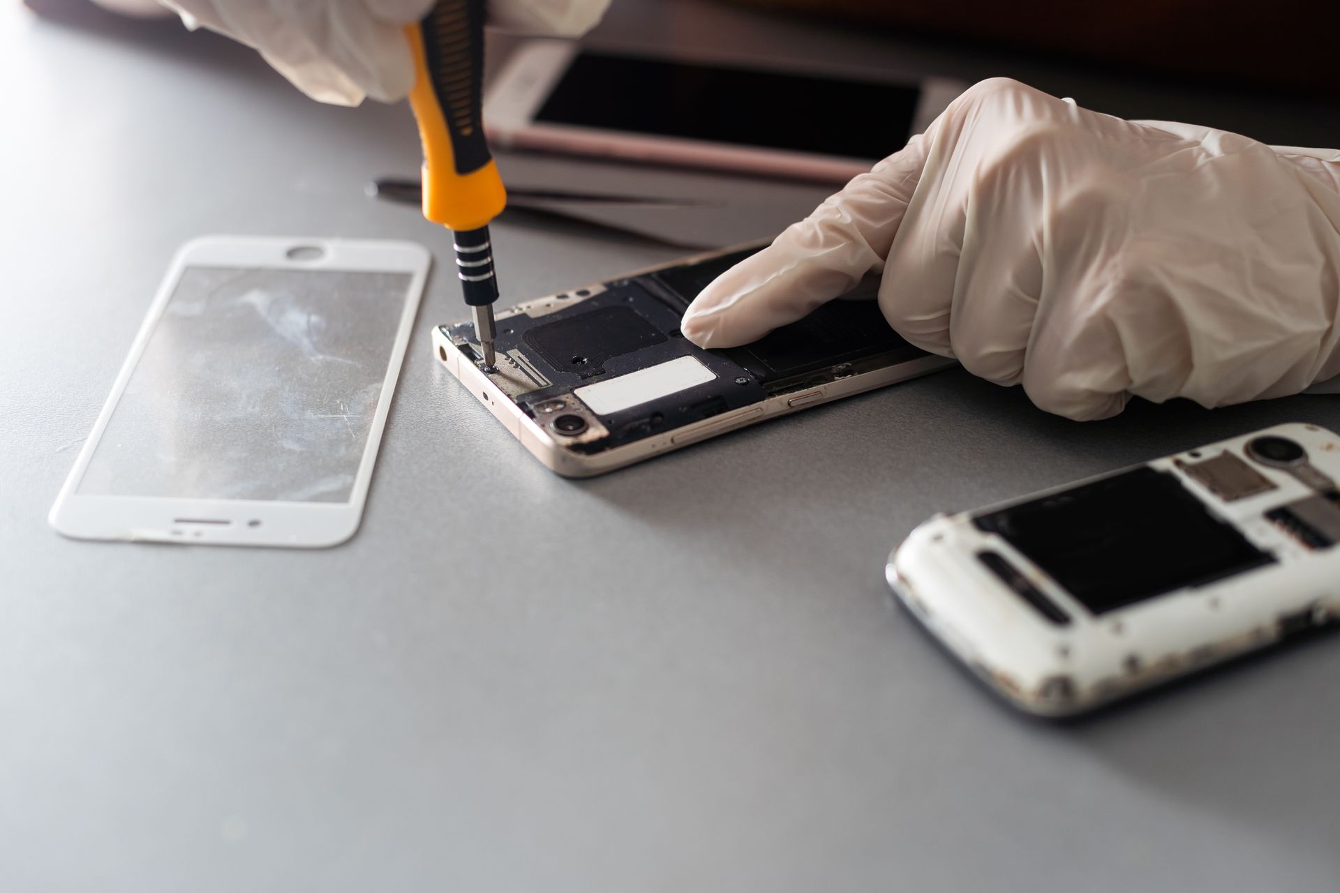 Una persona sta riparando un telefono cellulare con un cacciavite.