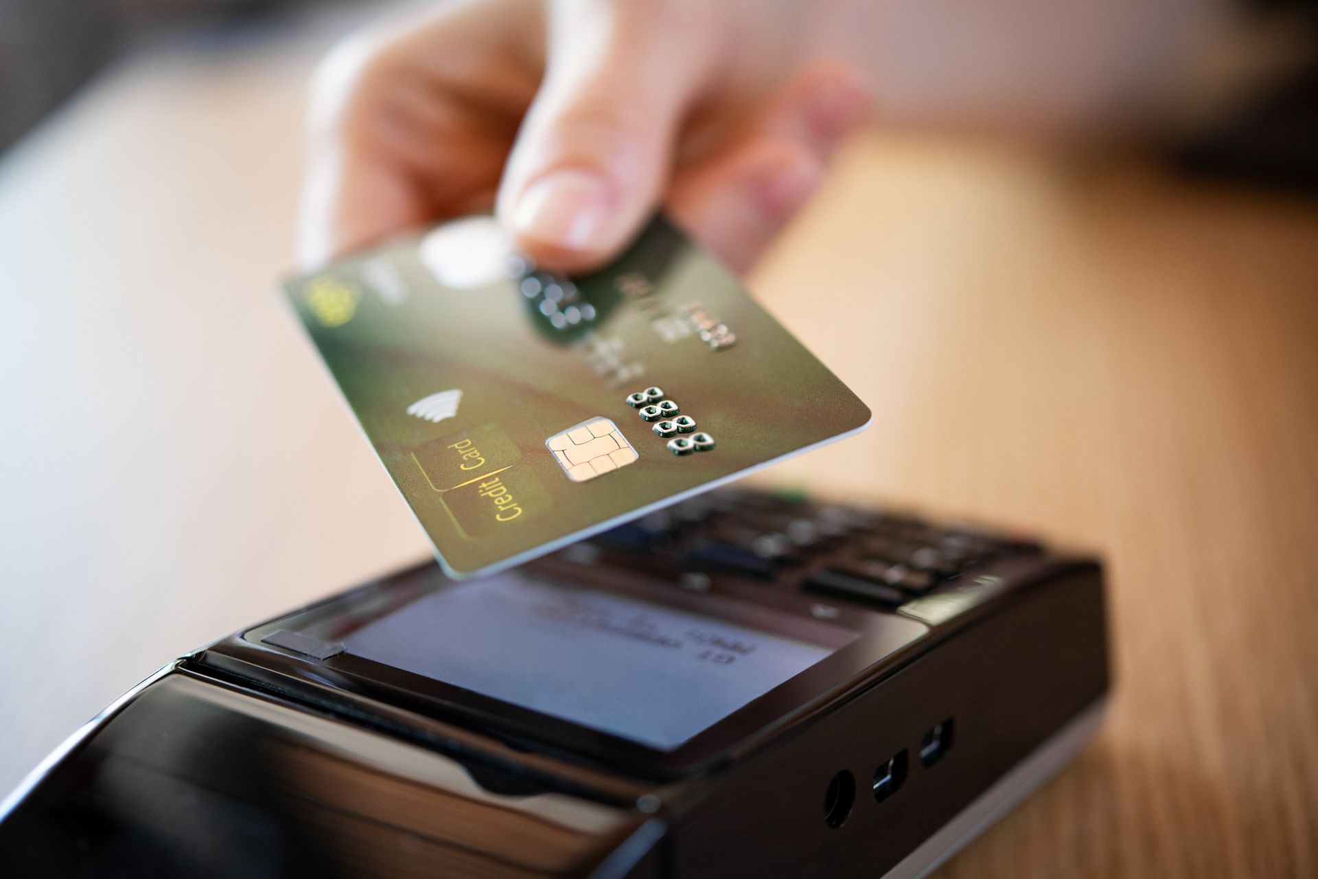 Una persona inserisce la carta di credito nel terminale per carte di credito.