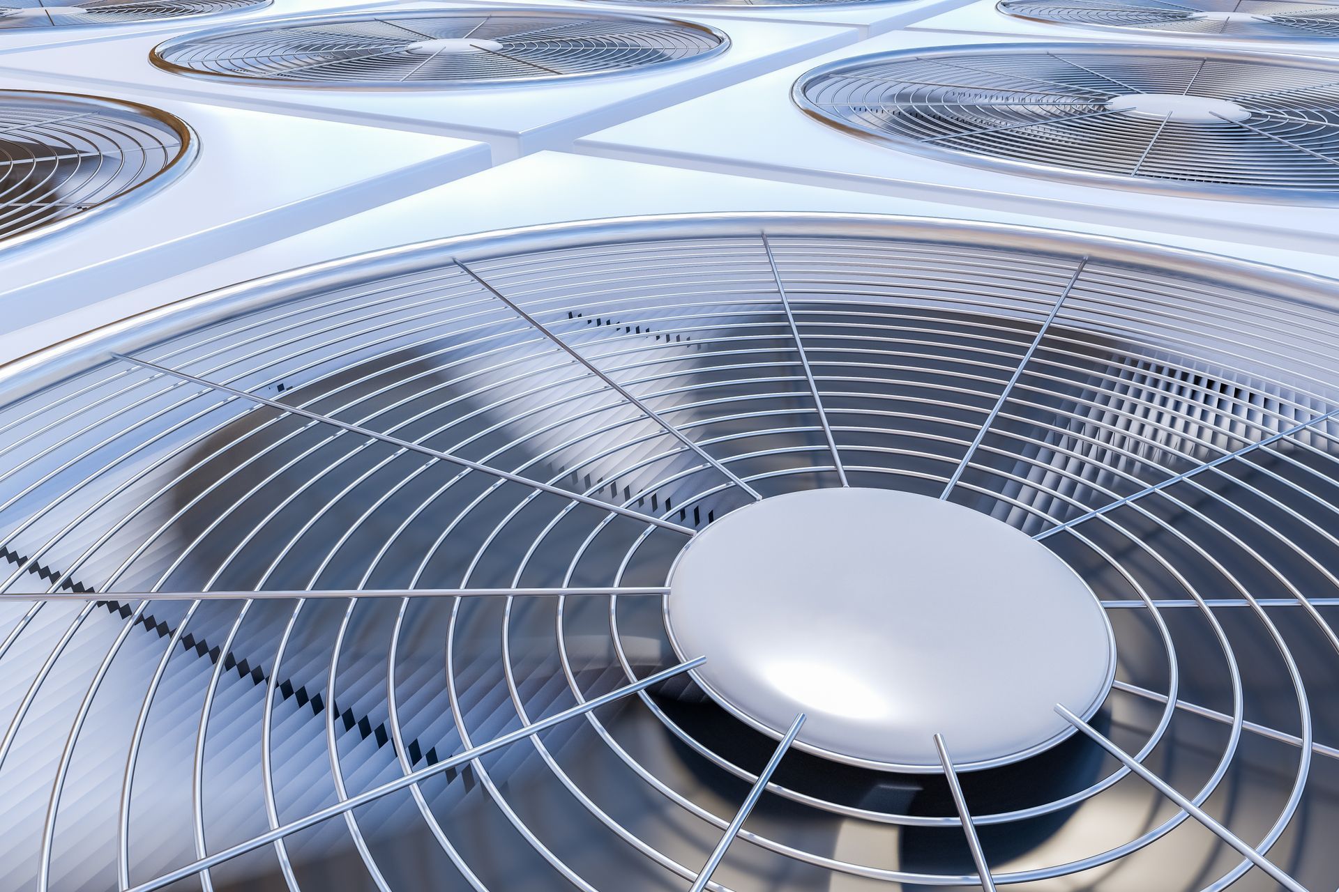 Close-up of large rooftop air conditioning fans in metallic grilles