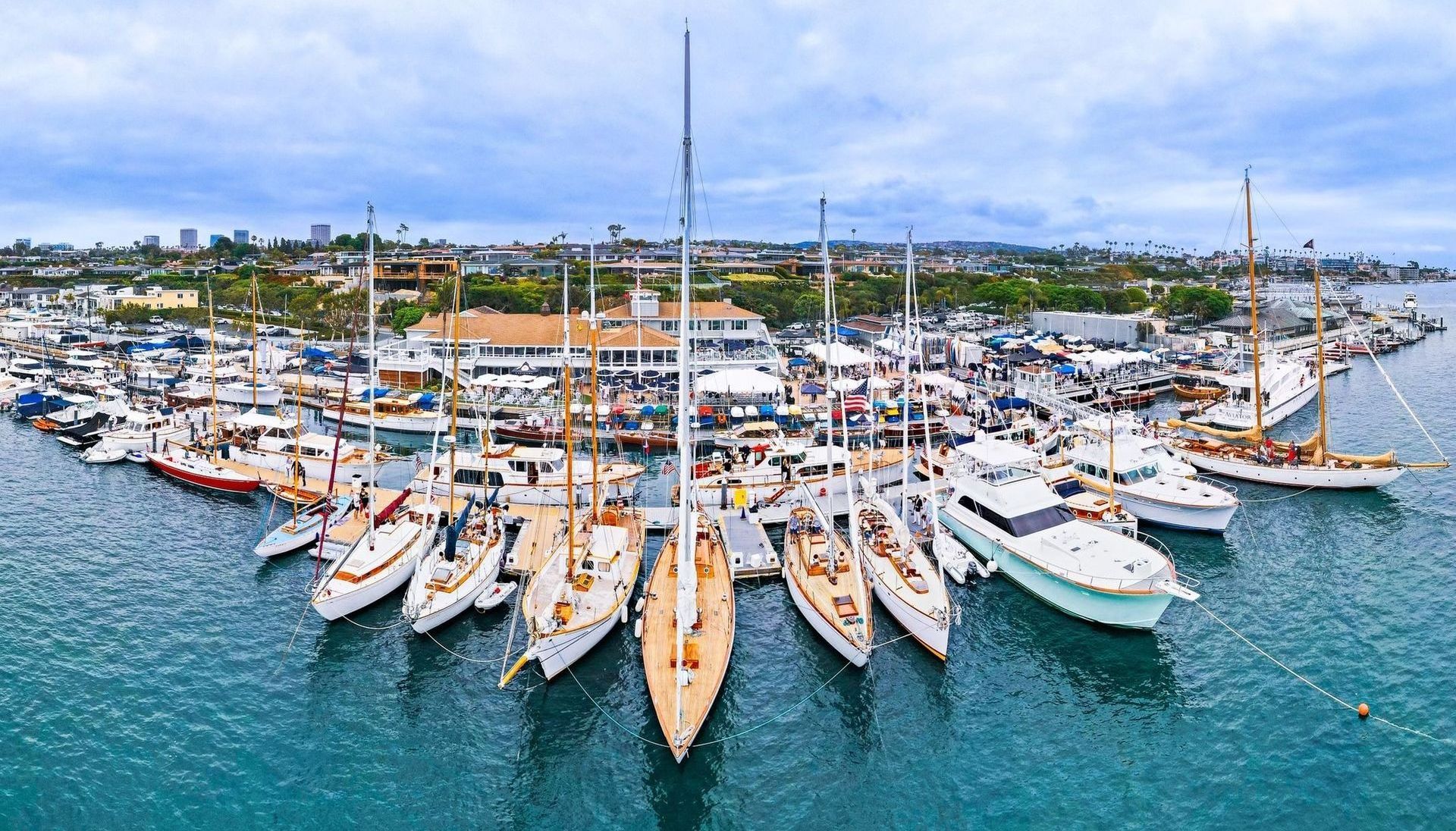 Marina full of sailboats and yachts docked on turquoise water under a bright sky