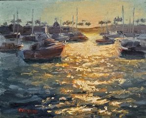 Sunlit harbor with moored boats and shimmering water at sunset