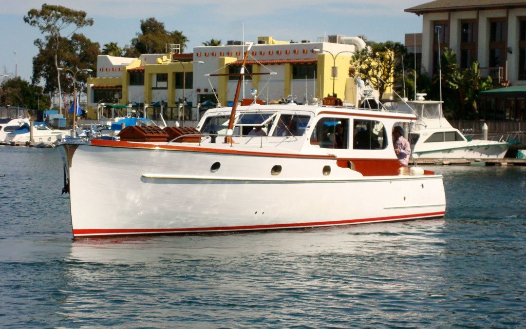 White boat on calm water near docks and waterfront buildings
