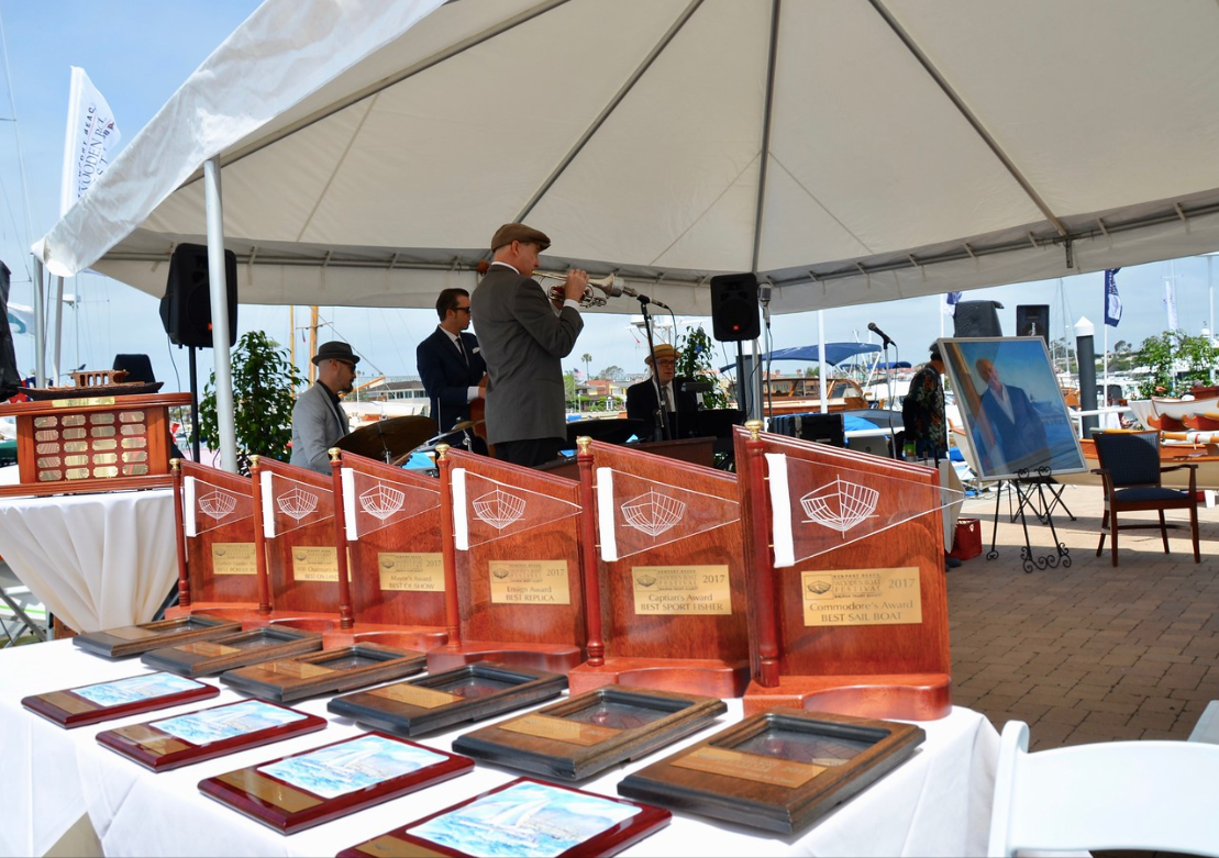Awards displayed on a table under a white tent at an outdoor event