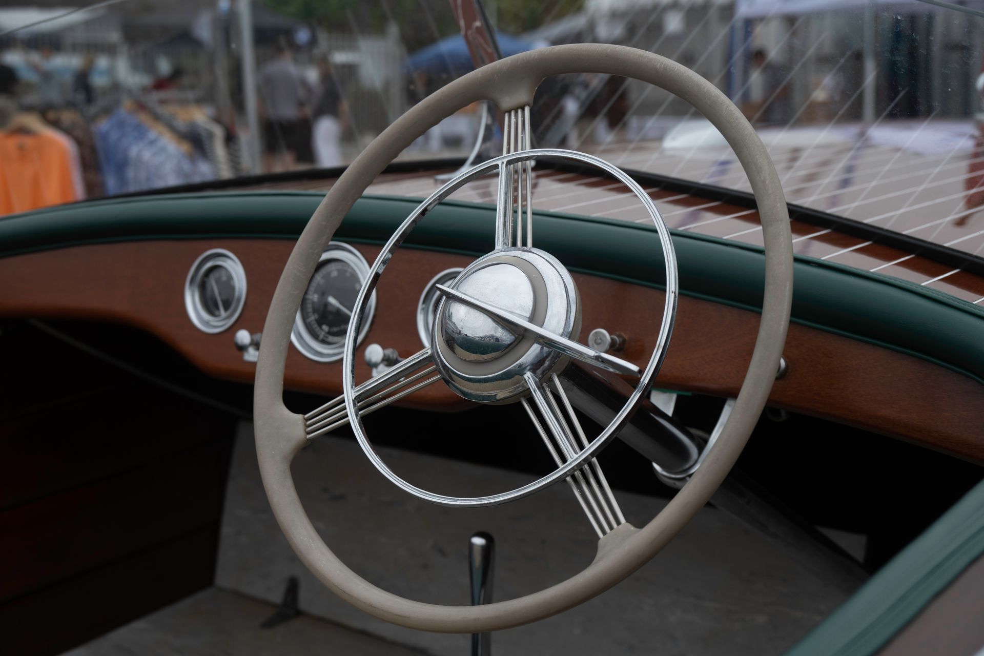 Vintage boat interior with cream steering wheel and wood dashboard detail.