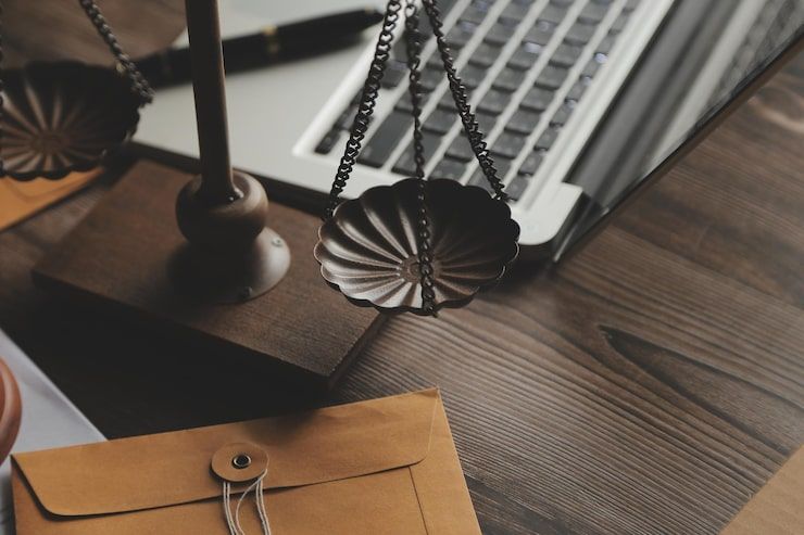 Retro desk setup with a laptop, brass lamp, and brown envelope on a wooden table